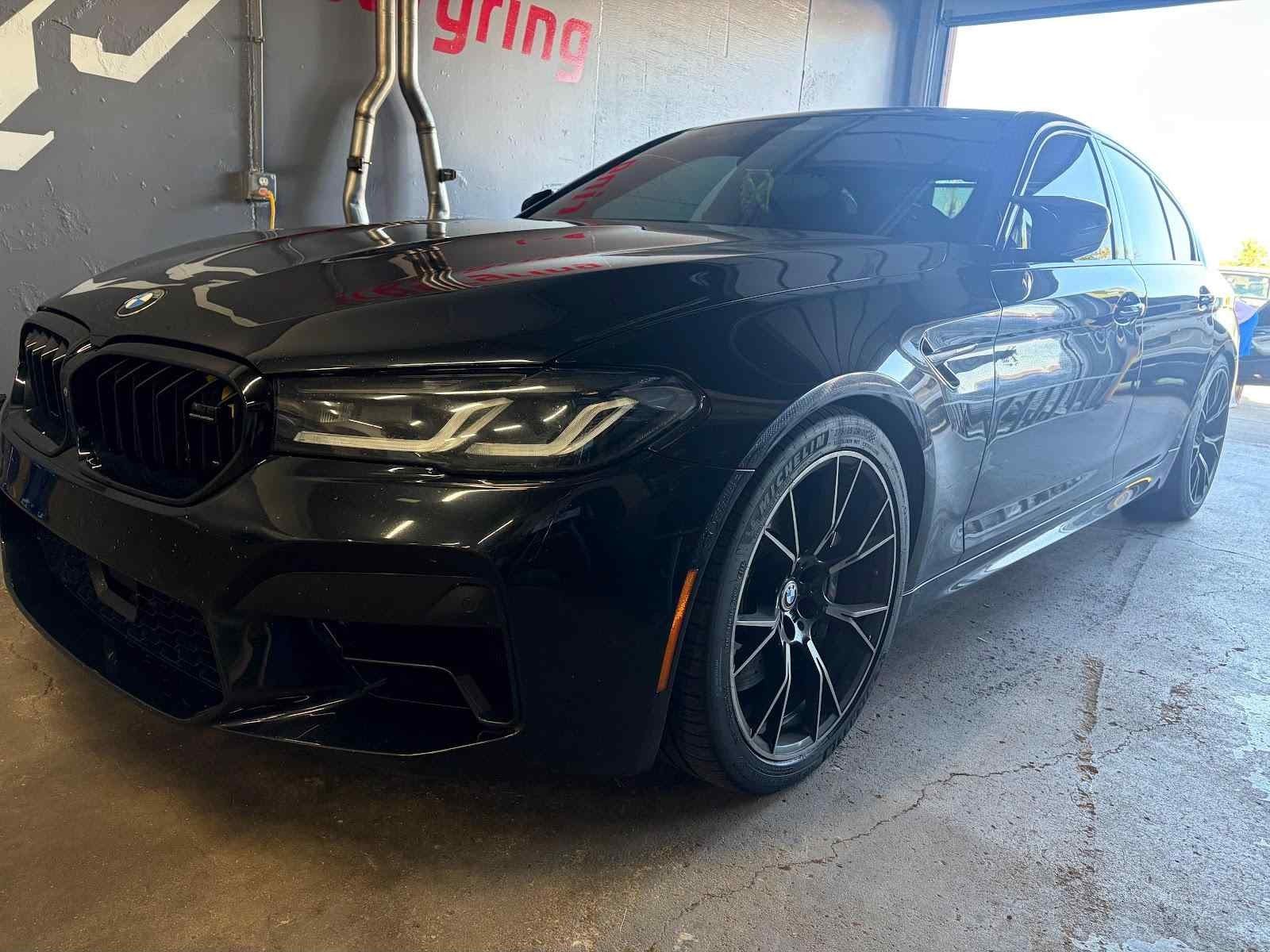 Black F90 M5 Competition in front of the Eins wall