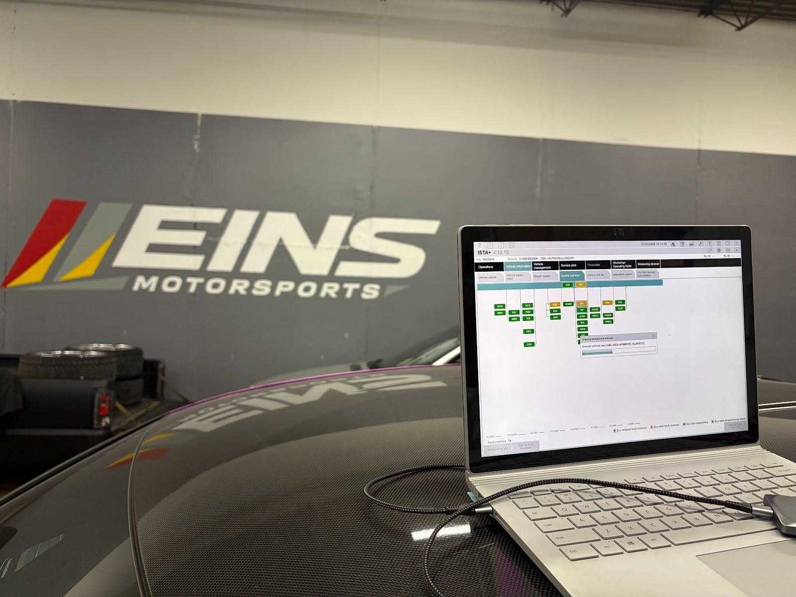 Diagnostic laptop on a carbon hood, Eins wall behind